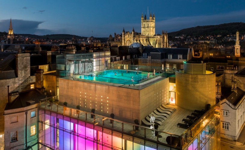 View of Thermae Bath Spa's rooftop pool and Bath Abbey at night